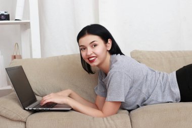 güzel genç gülümseyen kadın ile laptop Divan - kapalı