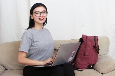 güzel genç gülümseyen kadın ile laptop Divan - kapalı