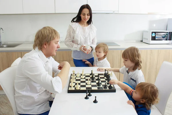 Семья играет в шахматы на столе дома — стоковое фото