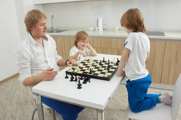 Famiglia che gioca a scacchi su un tavolo a casa — Foto Stock