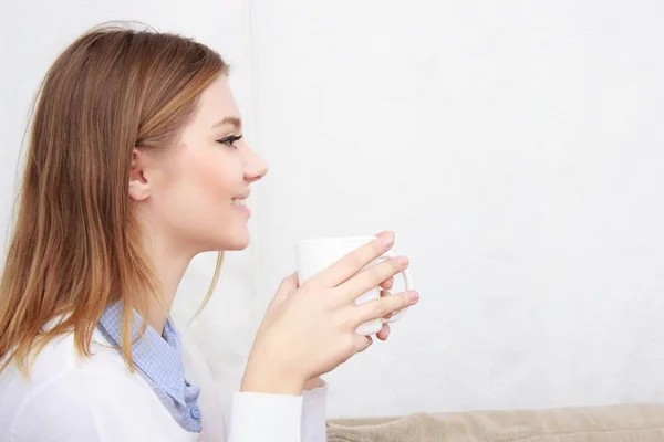 Donna seduta sul divano nel suo soggiorno e bere caffè — Foto Stock