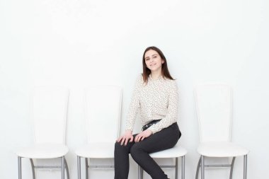 Çekici kız beyaz modern oturma sandalye ve evde sakin ol