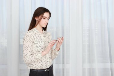 Akıllı telefon kullanan genç ve güzel bir kadın.,