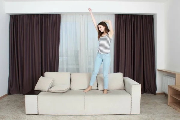 Adolescente chica saltando en el sofá — Foto de Stock