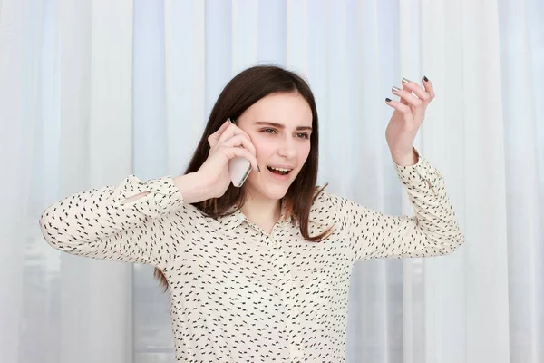 Leende kvinnlig student talar på telefonen isolerad på en vit bakgrund — Stockfoto