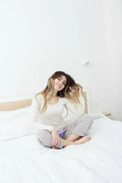 Mujer feliz acostada en la cama y despertando por la mañana —  Fotos de Stock