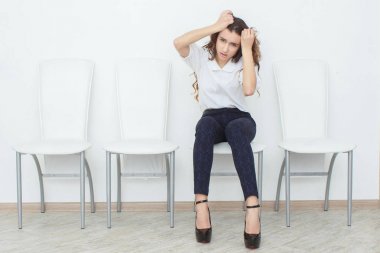 Güzel bir kız sandalye ve kızgın oturuyor