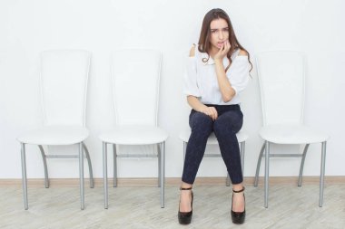 Güzel bir kız sandalye ve kızgın oturuyor