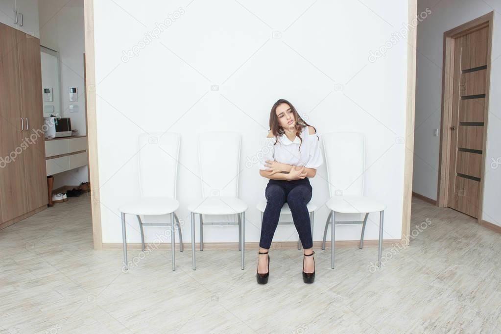 A beautiful girl is sitting on chair and angry
