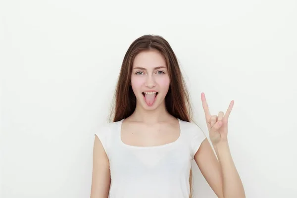 Ganska rolig ung flicka visar tungan och rock gest — Stockfoto