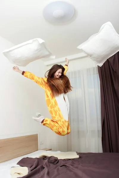 침대에 점프 kigurumi 잠 옷에 재미 있은 여자 — 스톡 사진