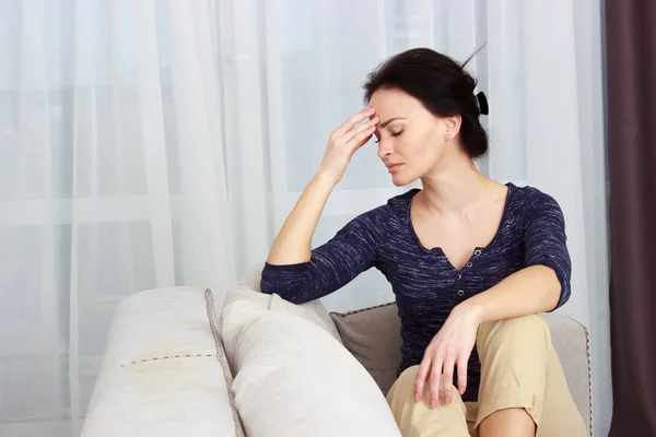 Молодая женщина страдает от головной боли дома, крупным планом — стоковое фото