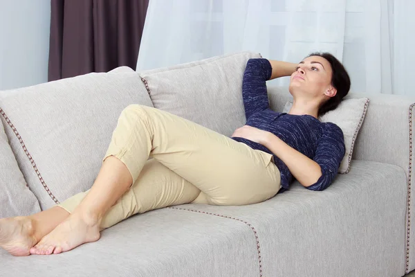 Красивая молодая женщина, лежащая на диване — стоковое фото