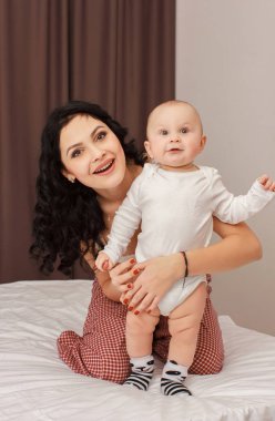 Anne ve bebek yatakta yatarken gülümseyen mutlu