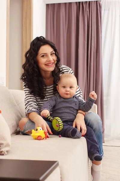 Young mother and her son play and reading a book on sofa, lifestyle — Stock Photo, Image