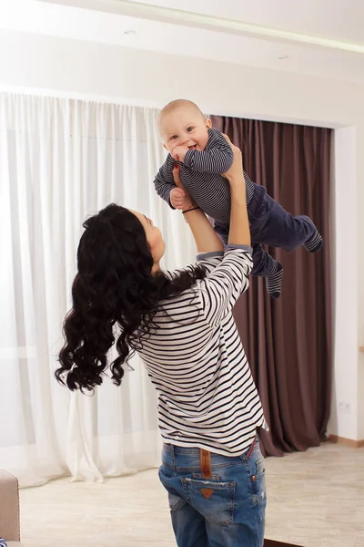 Jovem mãe e seu filho brincar e ler um livro sobre sofá, estilo de vida — Fotografia de Stock