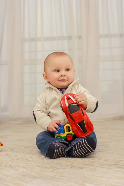 Söt baby pojke leker med leksaker i vardagsrummet — Stockfoto