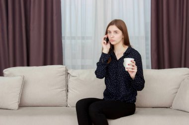 Çay ile evde kanepede oturan güzel genç kadın portresi