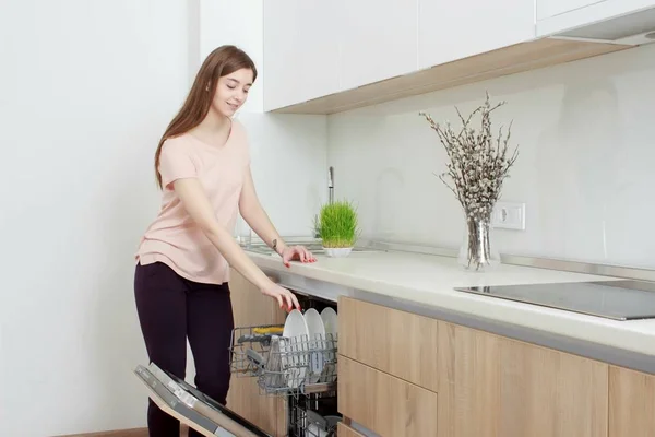 Kitchen Woman. Girl in the kitchen using dishwasher — Stock Photo, Image