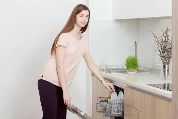 Mulher da cozinha. Menina na cozinha usando máquina de lavar louça — Fotografia de Stock