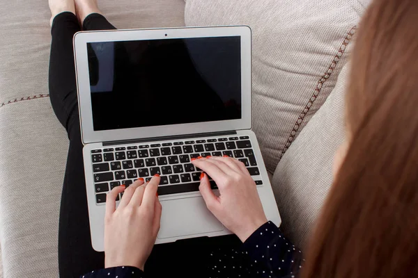 Dívka drží chytrého telefonu a chytré hodinky, sedící u notebooku — Stock fotografie