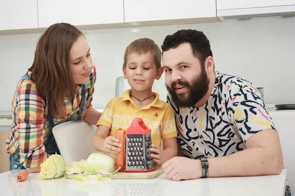 Family of three eating fruits in the kitchen, family in the kitchen, — Stock Photo, Image