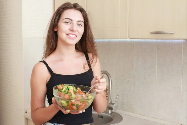 Portrait d'une fille qui a l'air positive et qui tient une bagarre avec de la salade . — Photo