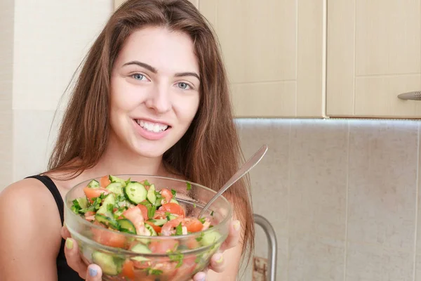 Retrato de uma menina que parece positivo e segurando um bawl com salada . — Fotografia de Stock