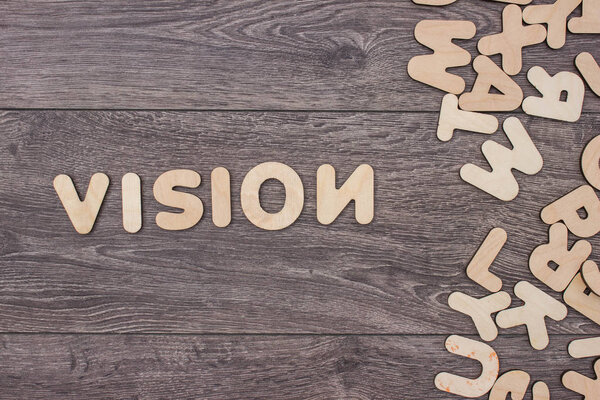 Слово, написанное деревянными буквами рядом с кучей других букв над деревянной доской
