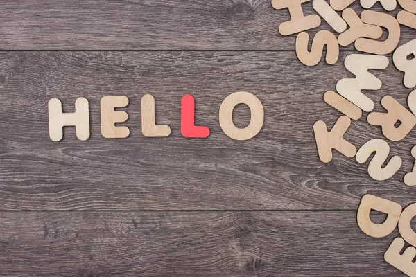 Palabra hecha con letras de madera junto a un montón de otras letras sobre el tablero de madera — Foto de Stock