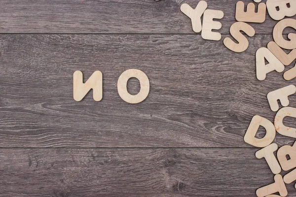 Parola fatta con lettere di legno accanto a un mucchio di altre lettere sulla tavola di legno — Foto Stock