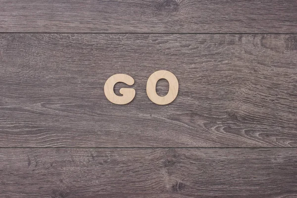 Palabra hecha con letras de madera junto a un montón de otras letras sobre el tablero de madera — Foto de Stock