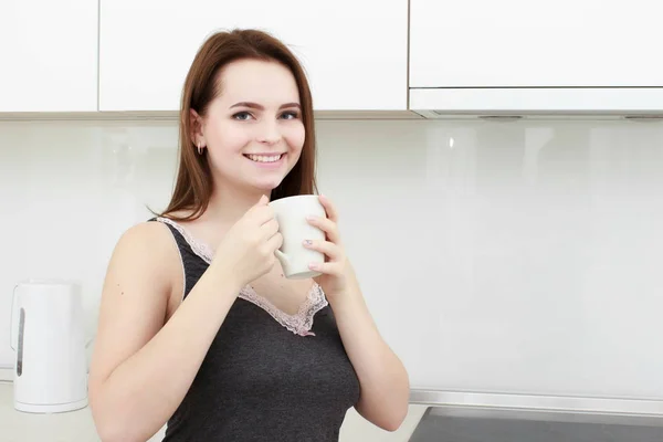 Jeune femme avec des cheveux noirs boire du café dans la cuisine — Photo