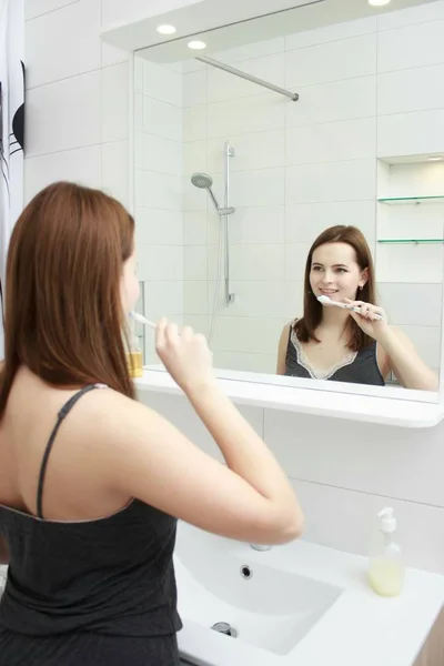 Retrato de chica feliz en el baño cepillándose los dientes — Foto de Stock