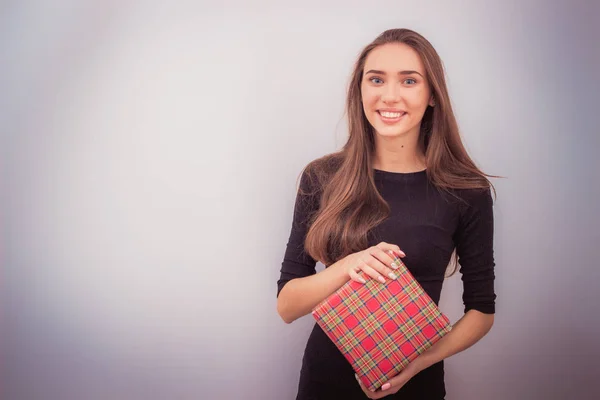 Mujer sonriente sostiene caja de regalo roja — Foto de Stock