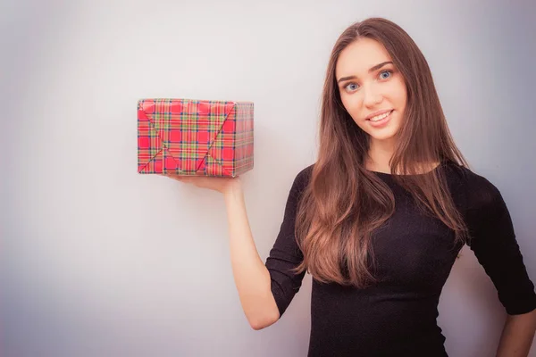 Mujer sonriente sostiene caja de regalo roja — Foto de Stock