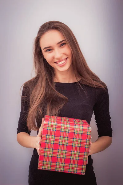 Mujer sonriente sostiene caja de regalo roja — Foto de Stock