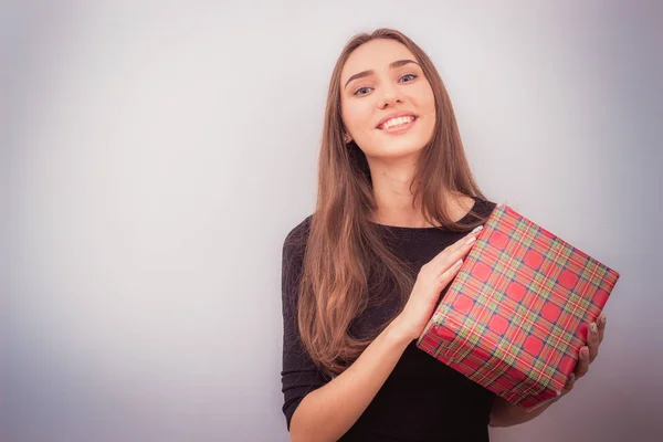 Mujer sonriente sostiene caja de regalo roja — Foto de Stock