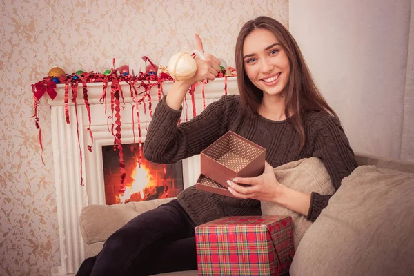 Smiling woman holds christmas tinsel — Stock Photo, Image