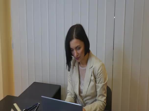 Серьезная женщина-руководитель работает за своим столом с ноутбуком — стоковое видео
