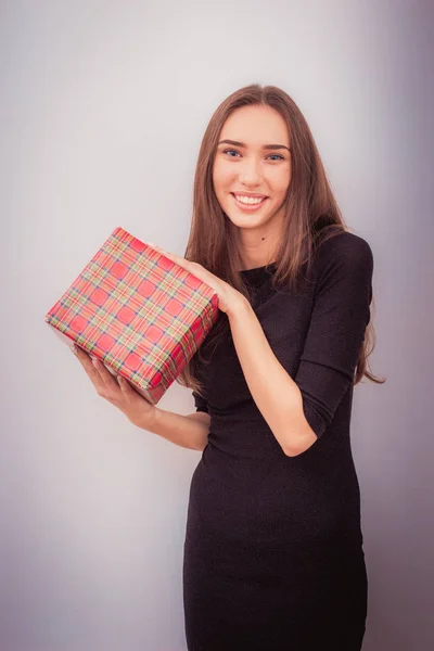 Mujer sonriente sostiene caja de regalo roja — Foto de Stock