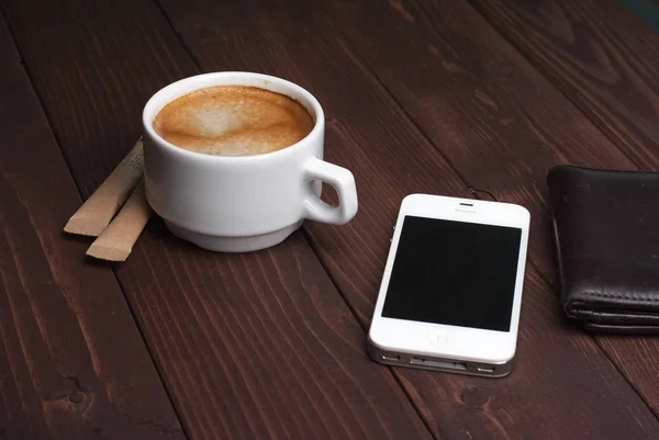 Smartphone med anteckningsbok och en kopp starkt kaffe på trä bakgrund — Stockfoto
