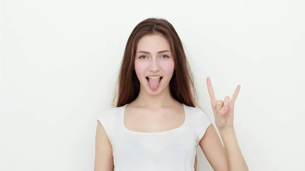 Ganska rolig ung flicka visar tungan och rock gest — Stockfoto