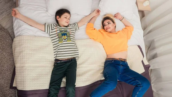Мати з сином на ліжку, мати і син розважаються — стокове фото