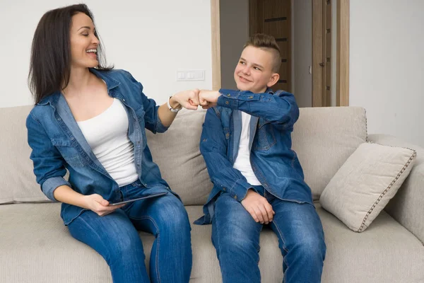 Familia feliz sentado en el sofá y el uso de la tableta digital en casa — Foto de Stock