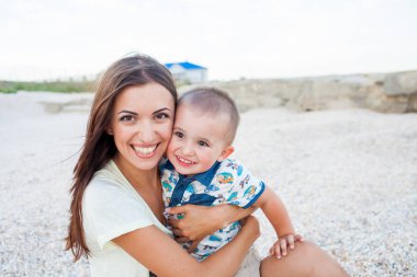 2 yaşındaki oğlu deniz kenarında tatilde olan mutlu bir anne.