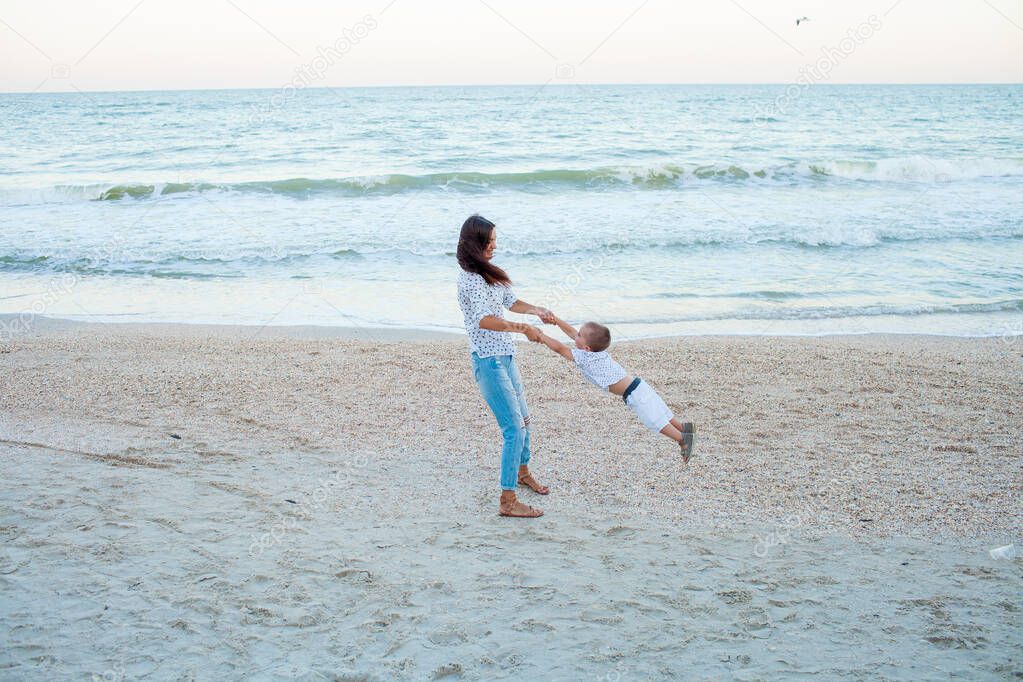 Mother and son playing near sea on seashore