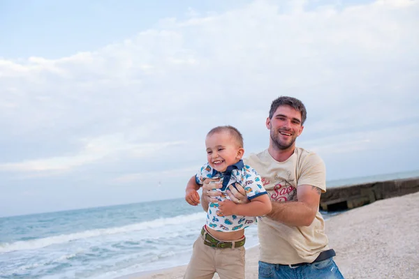 Padre que se divierte con su hijo a orillas del mar —  Fotos de Stock