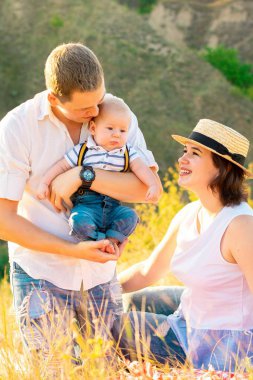 Aile yaz günbatımında bebekle.