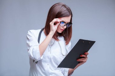 Doktor gözlüklü, covid-19 salgınıyla ilgili tıbbi belgeler tutuyor.